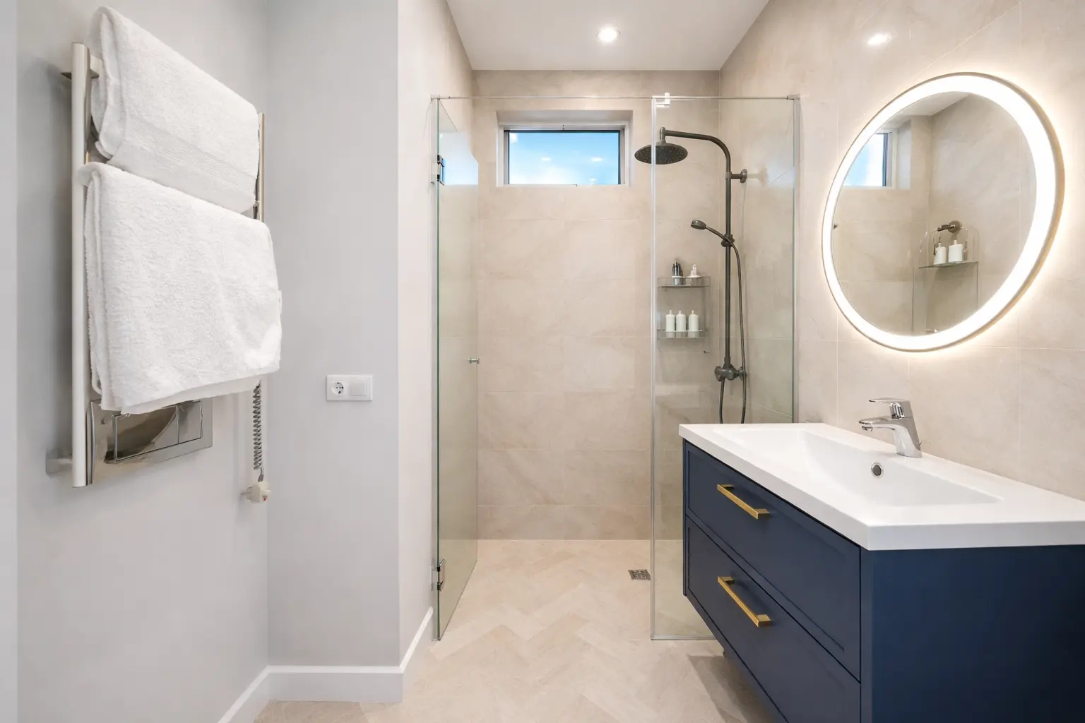 Walk-in shower and navy blue bathroom vanity with LED mirror
