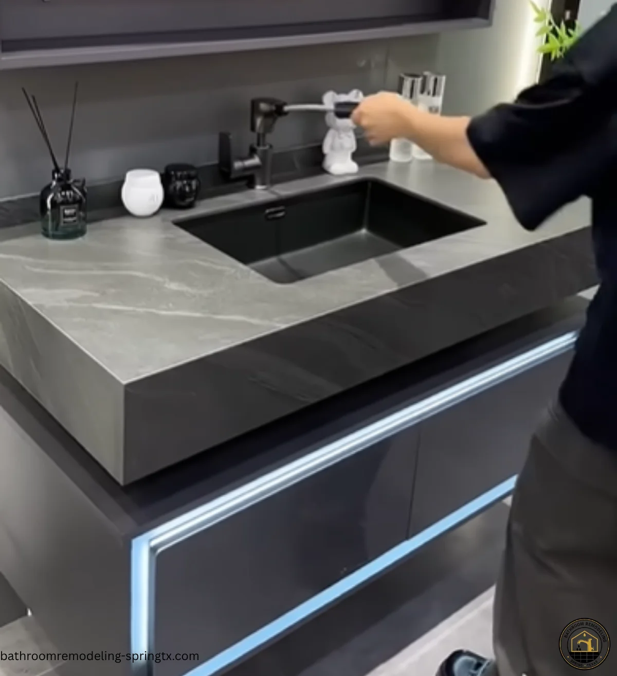 Person using modern dark vanity with black sink